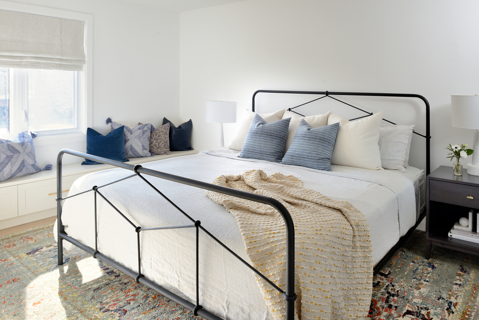 Minimalist bedroom with white walls and metal bed frame 