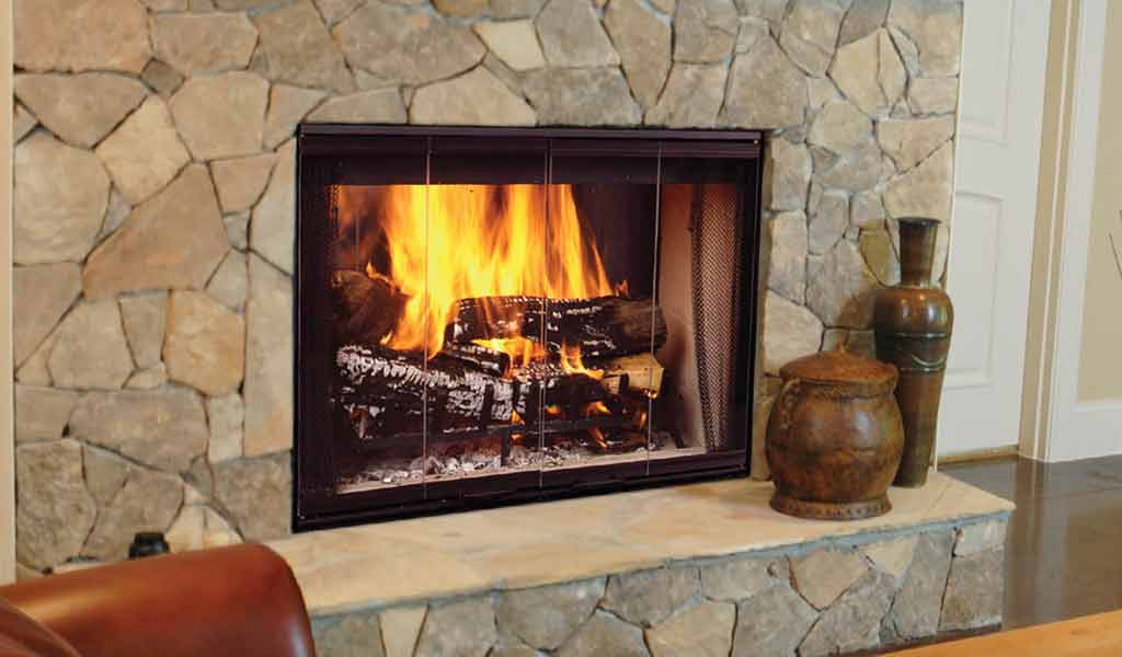 large stone fireplace with built-in wood storage warms a tile floor Photo: Gel Fireplaces
