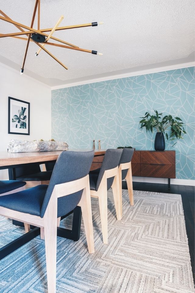 Blue wallpaper accent wall in dining room with geometric lines