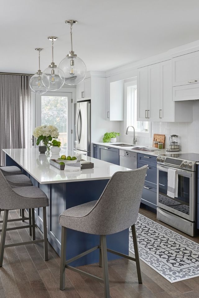 Dark blue lower cabinets with island and rug in white kitchen 