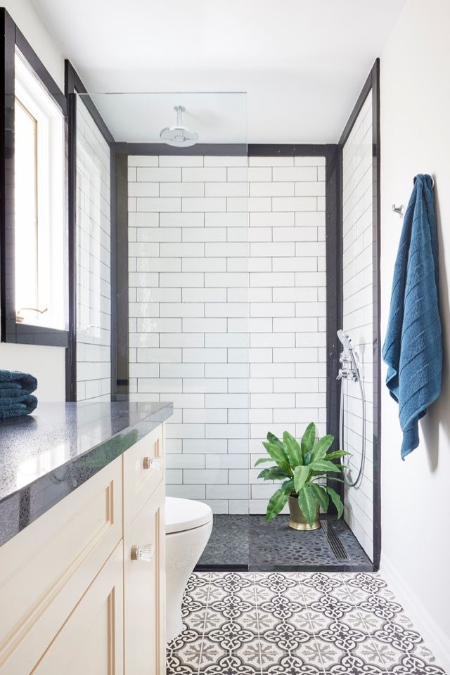 Doorless walk in shower with white subway tile and glass