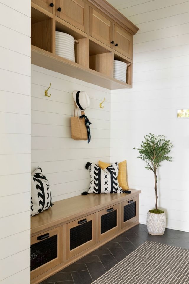 Entryway storage with built-in wood  cabinetry and shiplap walls
