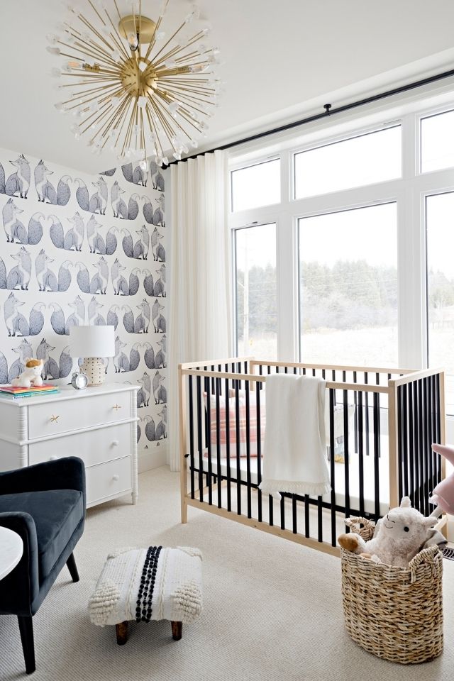 Trendy nursery room with wallpaper and large windows 