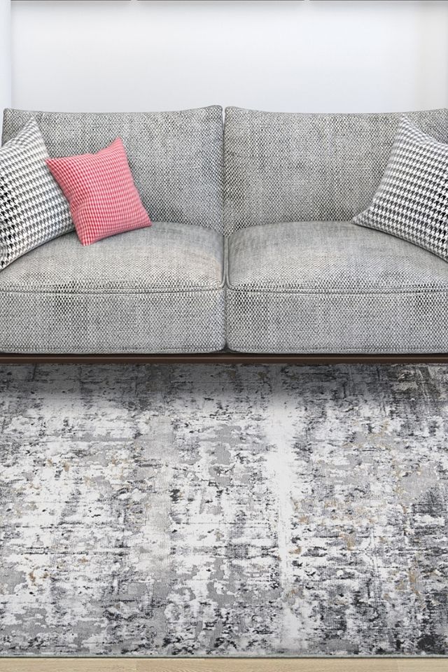 Gray living room area rug by Couristan with gray couch and abstract print