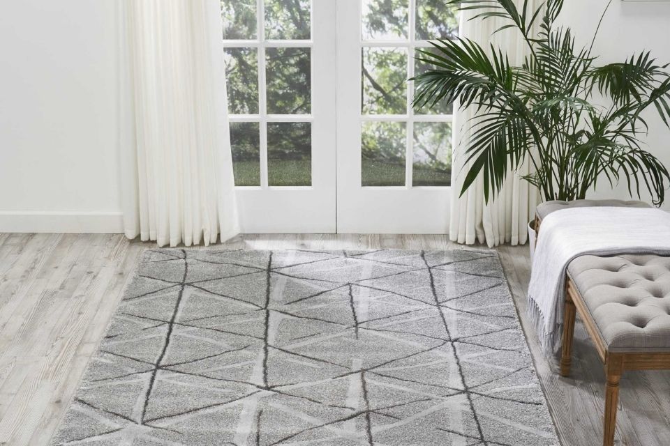 Geometric area rug with gray, white and black colors in living room with doors 