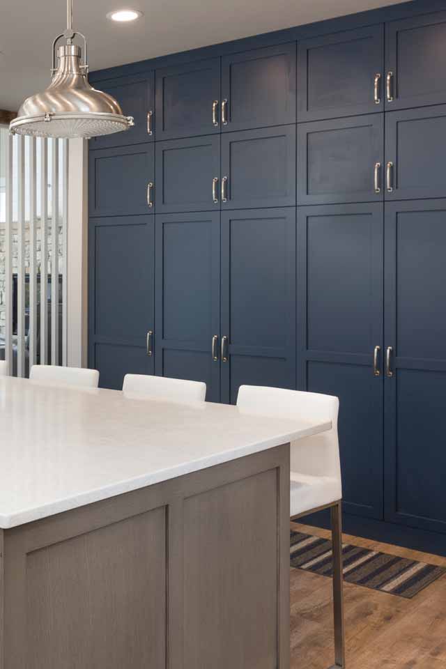 Custom blue cabinets behind a kitchen countertop designed by Floor to Ceiling Carpet One Floor and Home