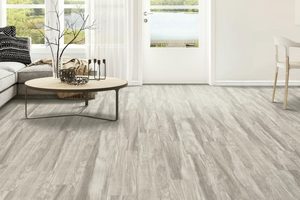 Light gray water resistant flooring in a light and bright living room 