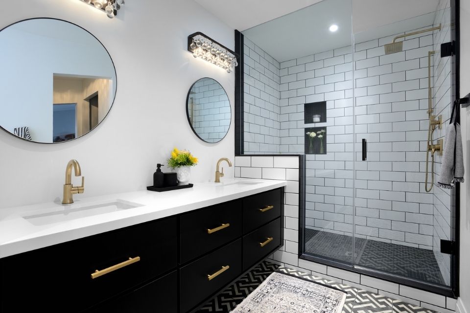 Black accents in modern style bathroom with black vanity and subway tile shower 