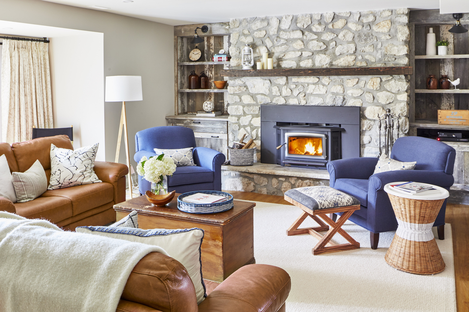 Warm fall inspired living room with fireplace and blue accent chairs by Rebecca Hay