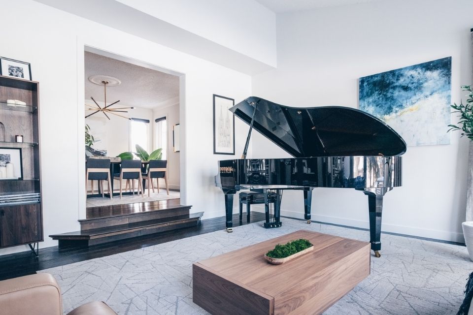 Piano in home design by Louis Duncan with wooden coffee table 