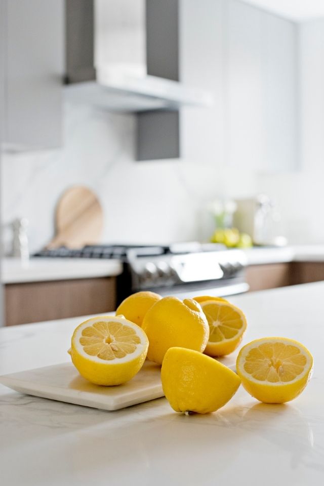 Lemons on top of white kitchen countertop in white kitchen 