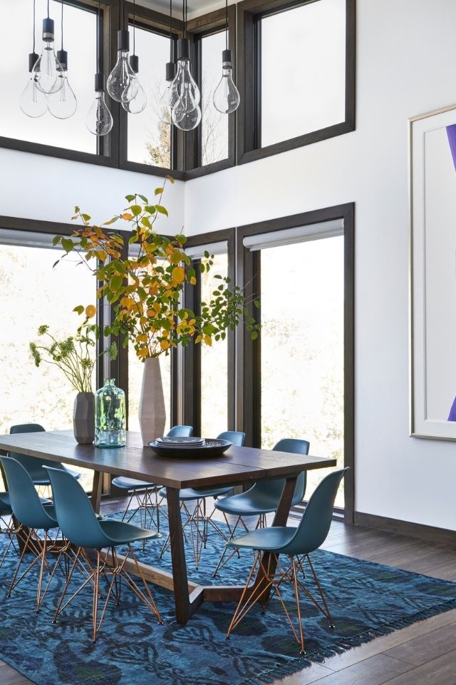 Bright dining room with turquoise area rug underneath dining table 