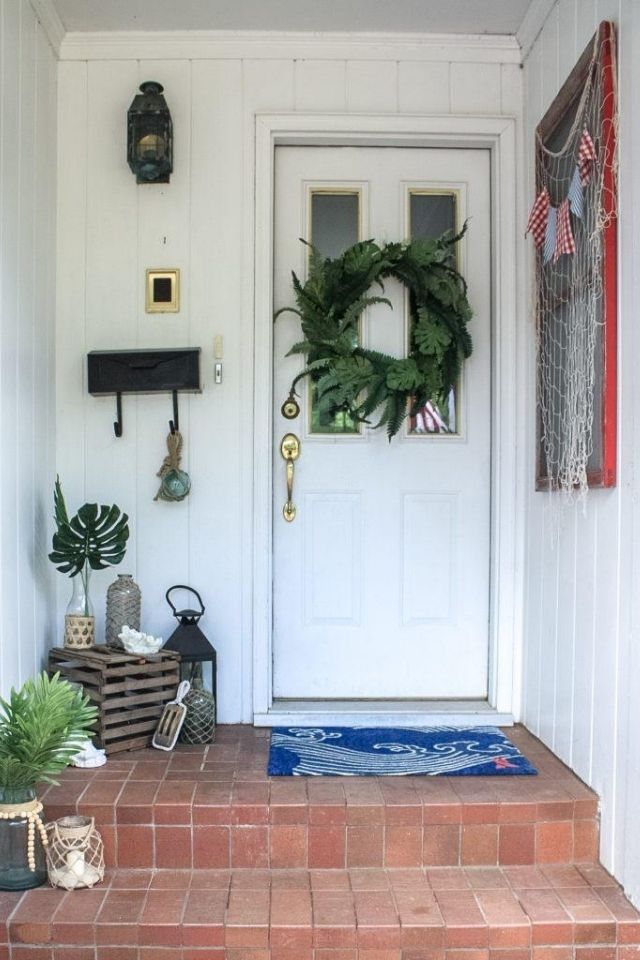 Front porch with beachy theme and blue welcome mat 