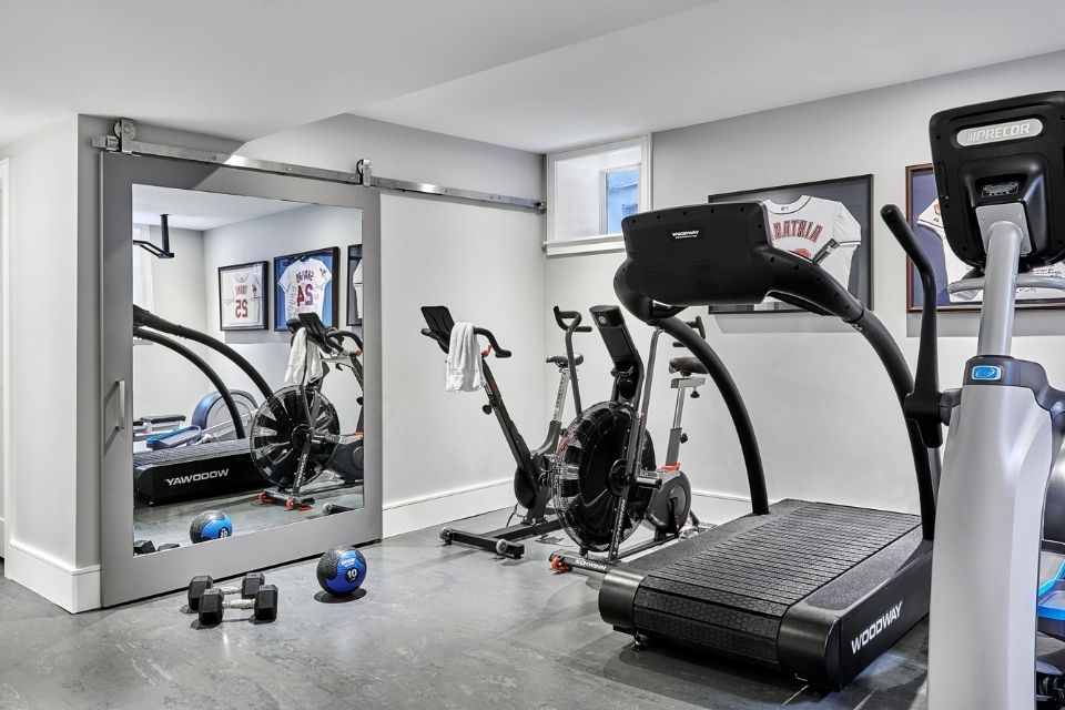 Home gym designed by Sara Bederman in basement with treadmill 