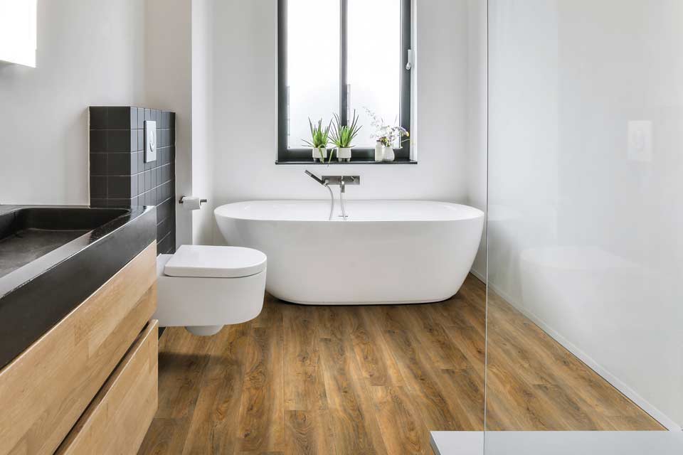 mid toned wood look luxury vinyl in modern bathroom with deep soak tub