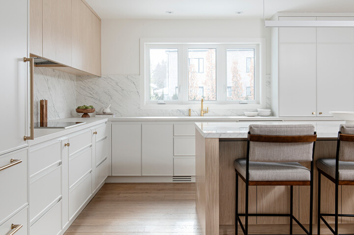 Kitchen with white cabinets and marble countertops.
